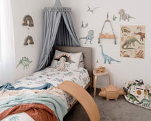Load image into Gallery viewer, Boys room with grey round canopy over bed with dinosaur decals on wall and dinosaur play pouch and wooden wobbel board