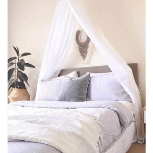 white drape canopy hanging above queen size bed in adult bedroom