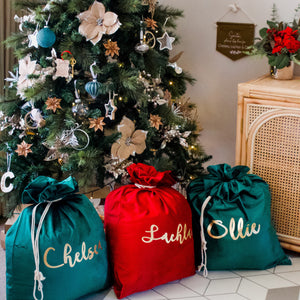 Three christmas santa sacks under a christmas tree