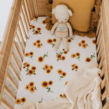 Load image into Gallery viewer, Snuggle Hunny Kids Sunflower Fitted Cot Sheet shown on a cot bed with throw , soft lamb toy and tassel cushion on top