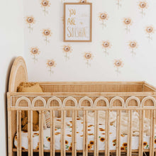 Load image into Gallery viewer, Snuggle Hunny Kids Sunflower Fitted Cot Sheet shown on a rattan cot bed with throw , soft lamb toy and tassel cushion on top