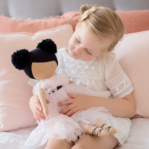 Alimrose Valentina Pom Pom Doll - Sparkle Pink - 48cm being held by a young girl with cushions behind her