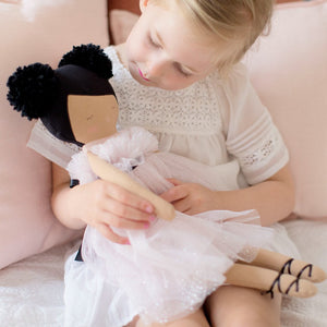 Alimrose Valentina Pom Pom Doll - Sparkle Pink - 48cm being held by a young girl with cusions behind her