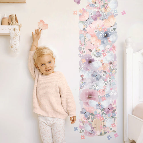 girl standing next to fairy garden floral height chart wall decal
