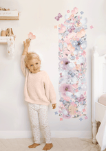 Load image into Gallery viewer, full view of blonde girl standing next to floral fairy garden wall decal height chart 