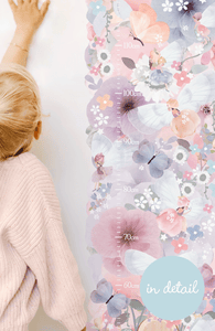 blonde girl measuring herself next to floral growth height chart wall sticker 