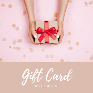 A picture of a womans hands holding a small brown box with a red ribbon and bow tied on top.