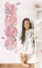 Load image into Gallery viewer, full view of girl standing next to pink peonie and purple butterfly wall decal height chart in bedroom