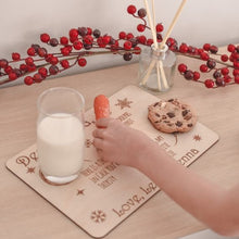 Load image into Gallery viewer, childs hand placing orange carrot onto wooden santa tray with half glass of milk and choc chip cookie
