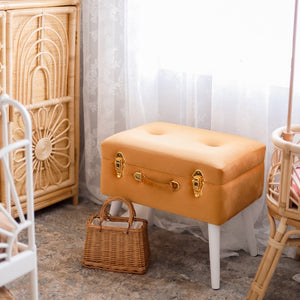 terracotta storage stool with gold clasp in girls bedroom with small handbag on ground