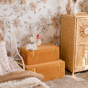 two terracotta storage boxes sitting on the floor of girls bedroom with toy sitting on top