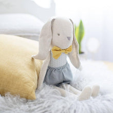 Load image into Gallery viewer, linen soft toy rabbit sitting on bed with mustard bow and grey linen shorts