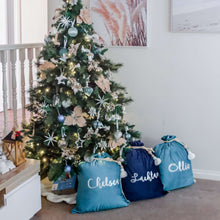 Load image into Gallery viewer, blue and navy santa sacks sitting under a christmas tree personalised in silver metallic font. The tree is decorated with blue and gold decorations.