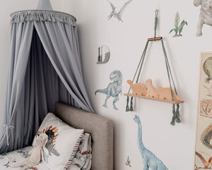 grey canopy hanging above bed in boys dinosaur themed bedroom. dinosaur wall decals and bedding 