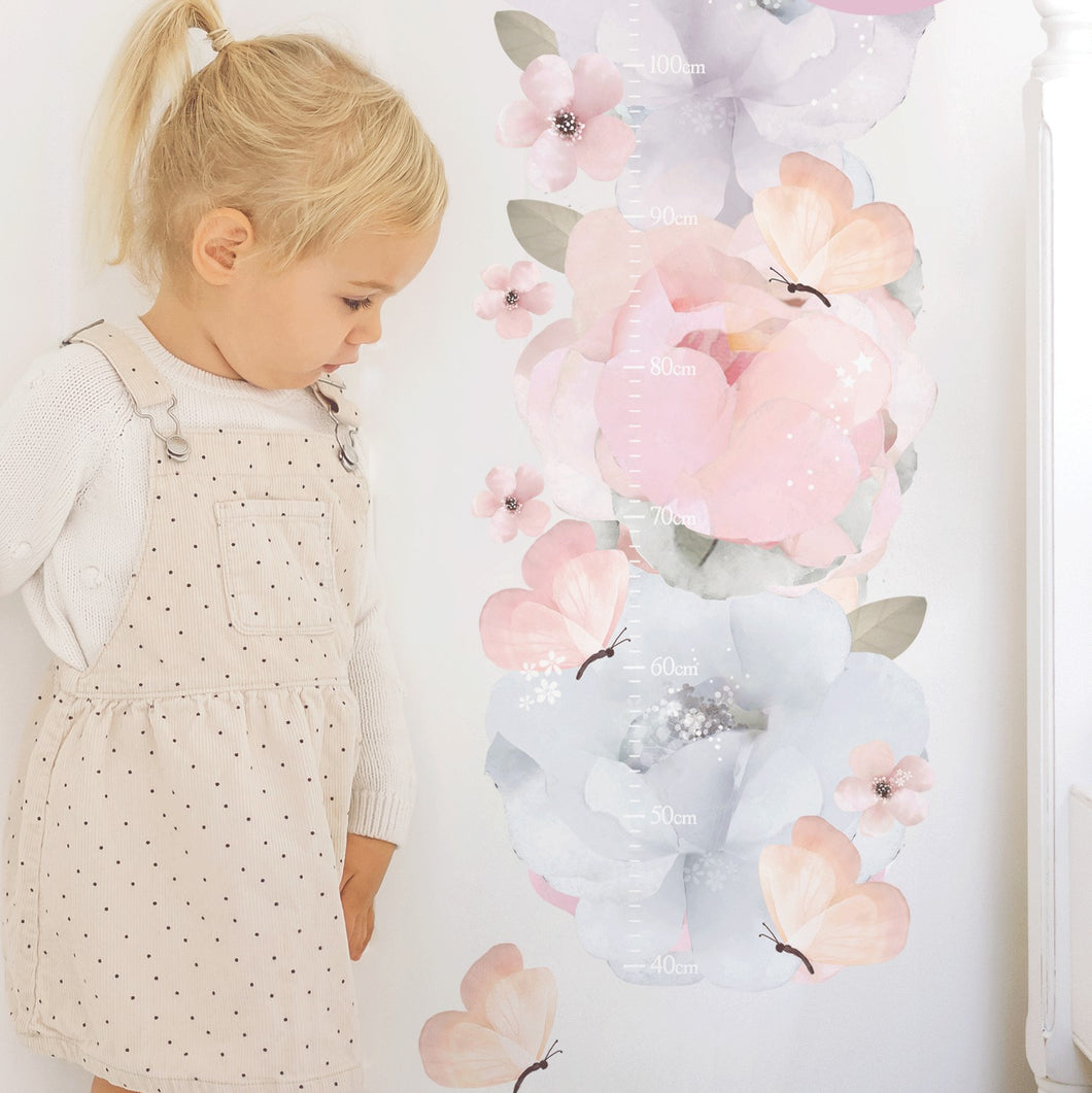 blonde girl looking at pink and blue floral wall decal height chart