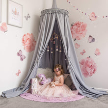 Load image into Gallery viewer, Grey Round Canopy over reading nook with large rose decals on wall and girl in tulle dress sitting on cushions underneath with a purple crochet rug on floor. 
