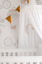 Load image into Gallery viewer, white canopy hanging above white cot in gender neutral nursery with mustard bunting and white swan mobile.
