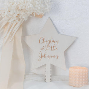 persoanlised star christmas topper leaning against a white wall