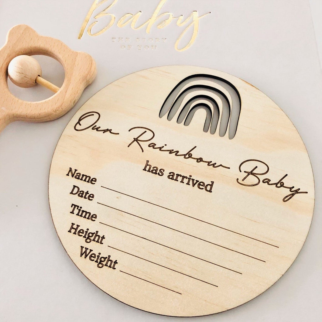 timber round birth announcement plaque with a rainbow on top 