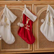 Load image into Gallery viewer, personalised red and white velvet santa stockings hanging on a rattan cabinet