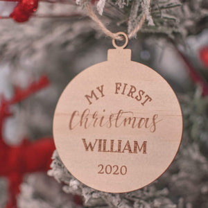 round wooden christmas tree ornament hanging on the christmas tree with the words My first christmas William 2020