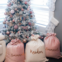 Load image into Gallery viewer, Christmas tree decorated with pink, white and rose gold decorations. Two pink and one ivory santa sacks are sitting in front of the tree and two white and silver stockings are hanging on the wall above the sacks. 