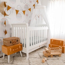 Load image into Gallery viewer, White round canopy hanging over white cot bed in nursery with mustard suitcase storage and mustard bunting with rattan toy truck on floor